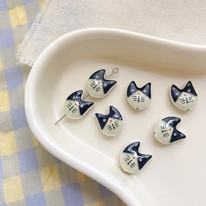 Macro detail of cat-shaped ceramic beads with hand-painted glaze for DIY jewelry making