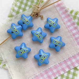 Close-up of star-shaped light blue resin beads featuring cute cartoon face for DIY crafts
