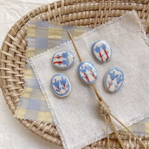 Primer plano de cuentas de cerámica pintadas a mano con tulipanes para joyería DIY