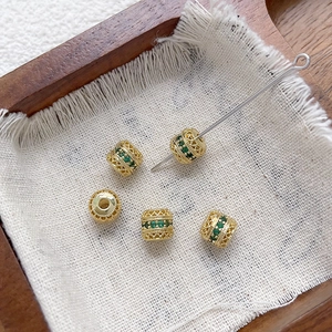 Detalle de cuentas espaciadoras huecas bañadas en oro de 18k con circonita verde