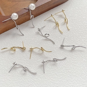Detailed view of assorted gold and silver geometric pearl earrings on white texture