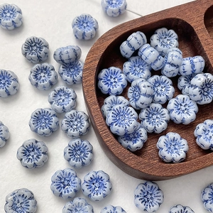 Macro view of blue and white floral glass beads with hand-painted glaze texture