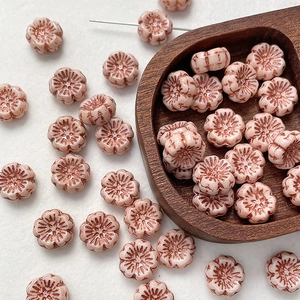 Macro shot of vintage pink floral Czech glass beads with antique finish and center hole
