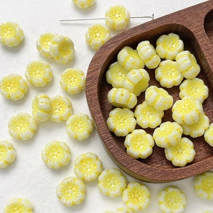 Macro view of flower-shaped Czech glass beads in creamy white with yellow edges for DIY