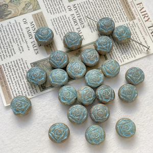 Close-up of hand-painted blue rose Czech glass beads for vintage DIY jewelry making