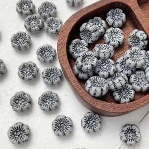 Macro detail of retro gray flower Czech glass beads with embossed texture for DIY jewelry