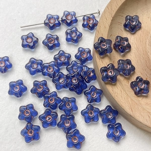 Detail of blue star-shaped Czech glass beads with bronze edges for DIY jewelry making