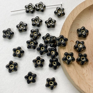 Detailed view of star-shaped Czech glass beads with gold centers for DIY jewelry making