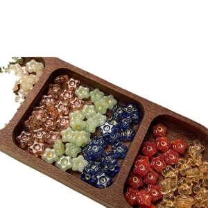 Hand-painted Czech glass flower beads in various colors arranged in a wooden tray for DIY crafts