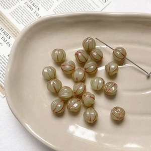 Macro detail of retro green pumpkin glass beads with golden texture for DIY jewelry