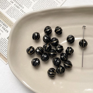 Close-up of vintage black pumpkin beads with gold accents for DIY jewelry making