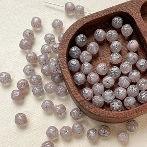 Macro detail of 8mm Czech glass rose beads with hand-painted marble texture for DIY jewelry