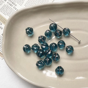 Macro detail of teal Czech glass pumpkin beads with retro gold gilding for DIY jewelry