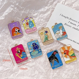 Detalle de los dijes de loros estilo tarot en esmalte con medidas de 29 mm de altura