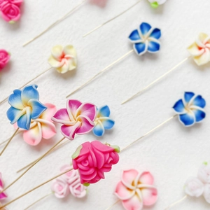 Gros plan détaillé d'épingles à fleurs en pâte polymère colorée pour bijoux artisanaux