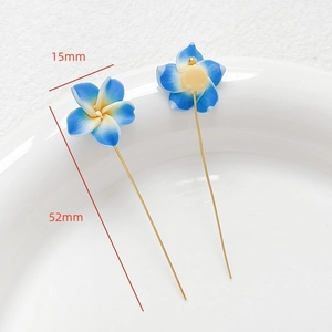 Détail macro de fleurs en argile polymère 15mm avec tiges en métal doré de 52mm