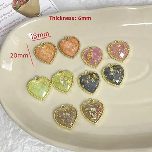 Detail of colorful resin heart charms with gold foil inlay and metal frame, 20x18mm size