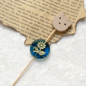 Detail of vintage blue bead with gold sunflower carving and small wooden bear charm pin