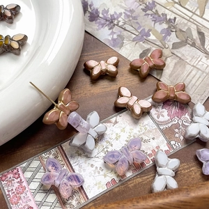Detailed view of colorful Czech glass butterfly beads with gold edges for jewelry making