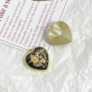 Detail of heart-shaped gold alloy pendants with gold foil and ribbed textures for DIY jewelry