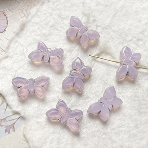 Macro shot of lilac Czech glass butterfly beads with silver gilding for DIY jewelry