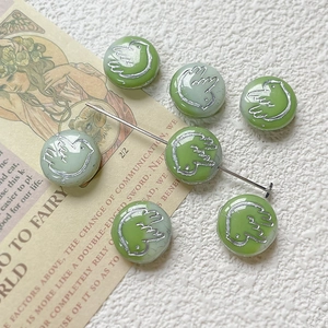Close-up of Czech glass green bird pattern beads for DIY handmade jewelry crafts