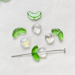 Detailed view of DIY glass tulip flower beads and green curved beads for jewelry making