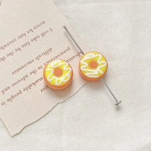 Detail of hand-painted doughnut resin beads for DIY jewelry making on vintage backdrop
