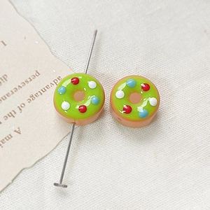 Close-up of donut-shaped glass beads in green and brown for DIY jewelry making