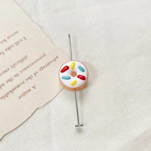 Macro detail of a glaze donut bead with metal pin for DIY jewelry making