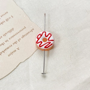 Detail showing orange donut glass bead on a 5cm metal pin for DIY jewelry making