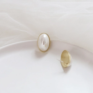 Close-up of 925 silver oval imitation pearl earrings with elegant gold-rimmed edges