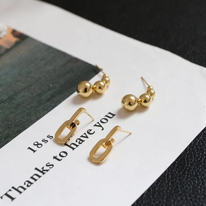 Gold plated bead earrings and oval link hoops set on a minimalist background