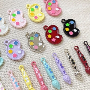 Close-up of colorful alloy paint palette and brush pendants for DIY jewelry making