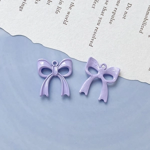 Dettaglio di ciondoli a fiocco in lega viola chiaro con lato lucido e retro con texture