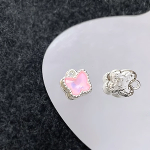 Detailopname van roze vlinderhanger met zilveren gehamerde afwerking voor DIY sieraden