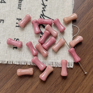 Dettaglio di perle in pietra rosa a forma di bambù con foro per gioielli fai-da-te