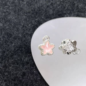 Detailopname van stervormige DIY-sieradenbedels met roze opaal en gehamerde zilveren textuur