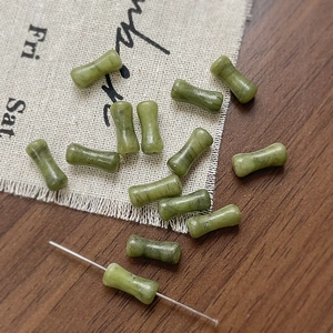 Dettaglio macro di perline in pietra naturale verde a forma di bambù per gioielli fai-da-te