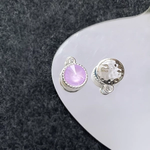 Detail van lavendel kristallen hanger en zilveren gehamerde schijf voor DIY sieraden