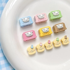 Cute cartoon toast and toaster resin beads for DIY jewelry making on a white plate