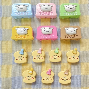 Macro shot of cute cartoon toast and bread toaster resin beads for DIY jewelry making