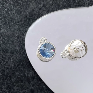 Macro-opname van blauwe edelsteenbedeltjes met gehamerde zilveren textuur voor sieraden