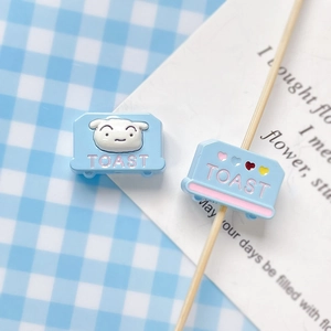 Close-up of light blue resin toast charms with TOAST lettering for DIY jewelry making