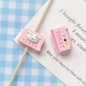 Close-up of cute pink toast beads with small dog and heart details for DIY jewelry