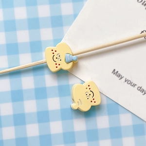 Detailed view of hand-painted toast bread charms with cute smiley faces for DIY jewelry