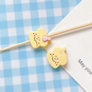 Close-up of cute hand-painted yellow toaster beads and charms for DIY jewelry making
