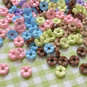 Gros plan de perles pastel en forme de fleurs pour la fabrication de bijoux DIY