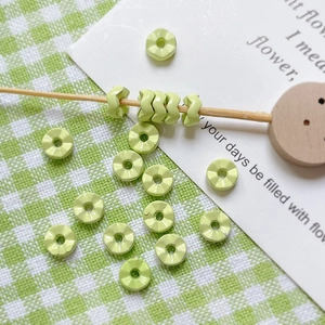 Détail de perles disques facettées vert clair avec trou central pour bijoux DIY