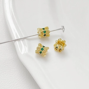 Macro shot of 18K gold-plated spacer beads with green zircons for jewelry making